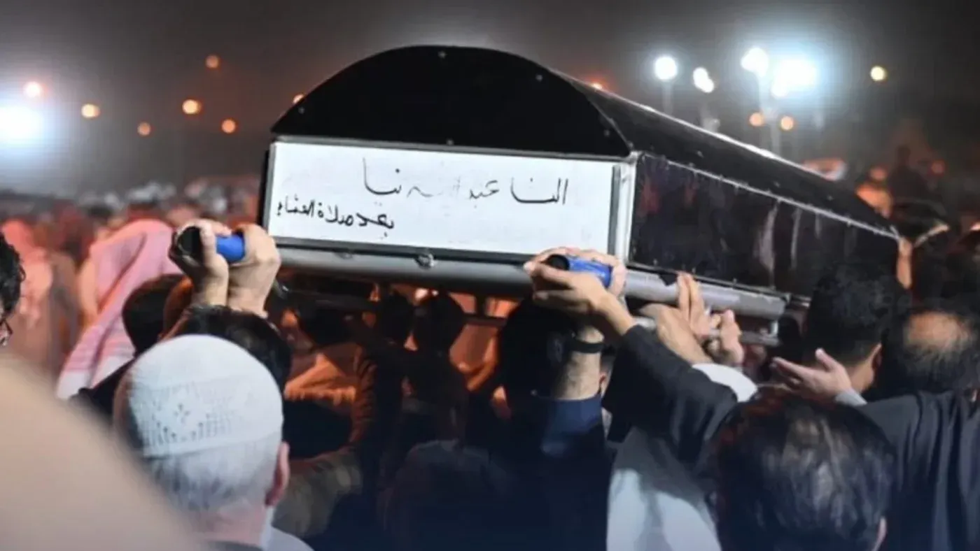 تجمع حشد من الأشخاص حول جنازة الطفلة الكويتية ألنا عبد الله، حيث يحملون النعش في أجواء حزينة تعكس تأثير الهجمات الإيرانية.