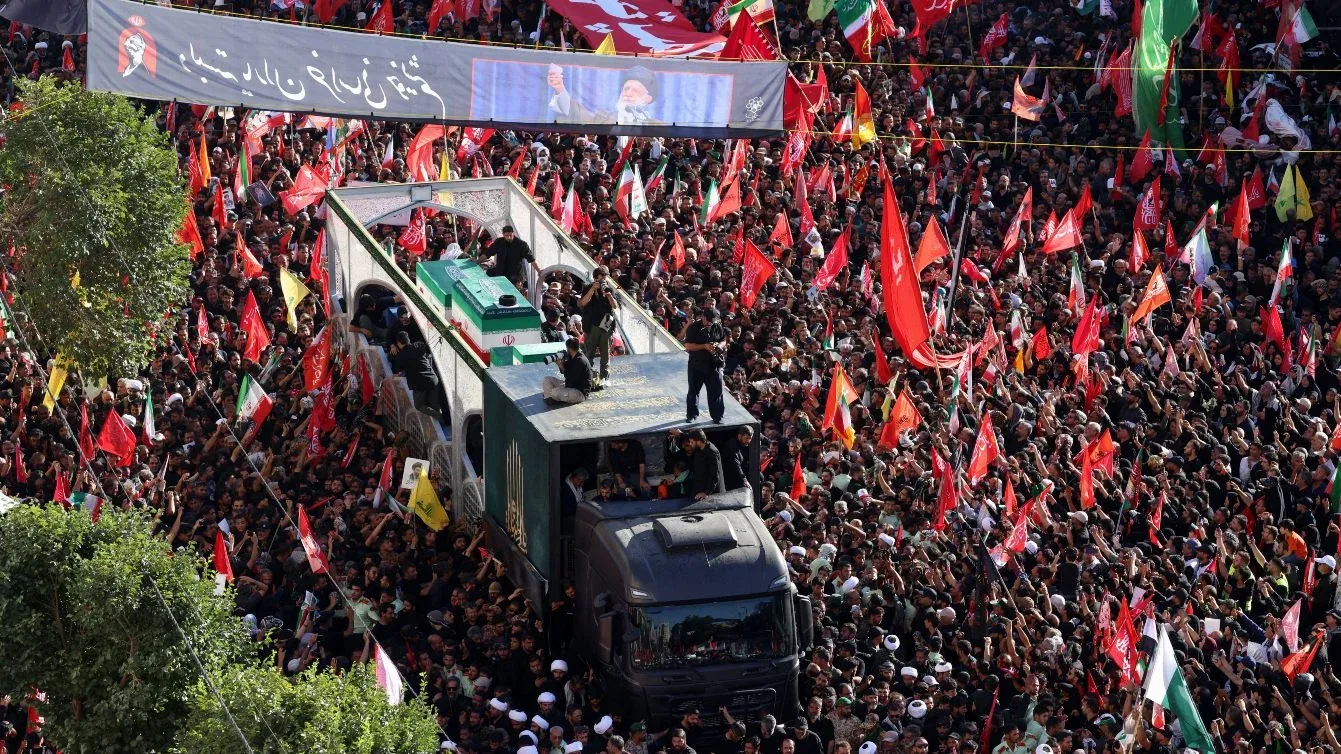 موكب جنازي ضخم يشيع نعش آية الله علي خامنئي وسط حشود غفيرة ترفع أعلامًا حمراء وشعارات تطالب بالانتقام في مشهد تاريخي بإيران.
