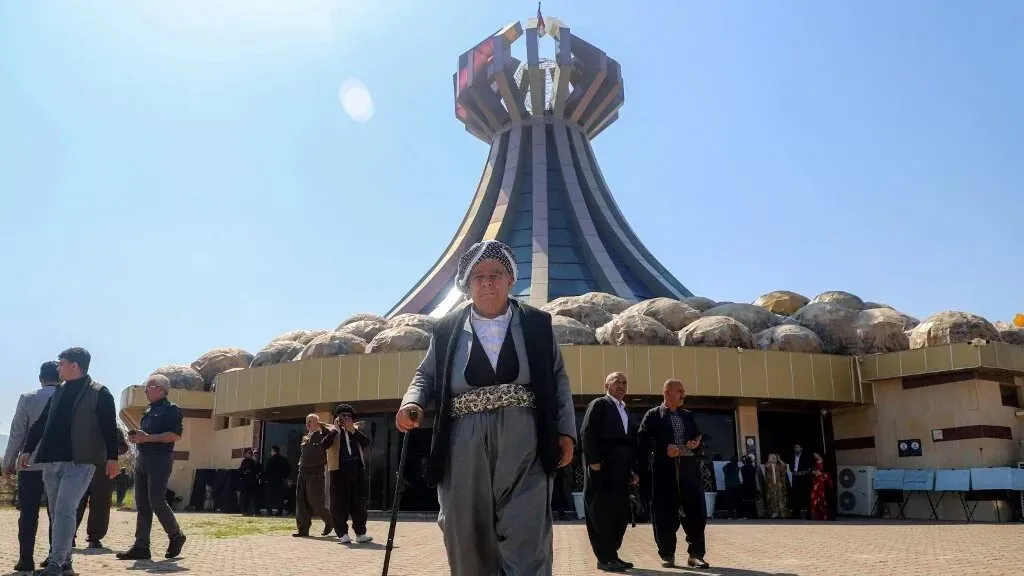 مواطنون يسيرون أمام معلم تاريخي في حلبجة، عقب إعلانها محافظة جديدة، في خطوة تعكس العدالة للضحايا.