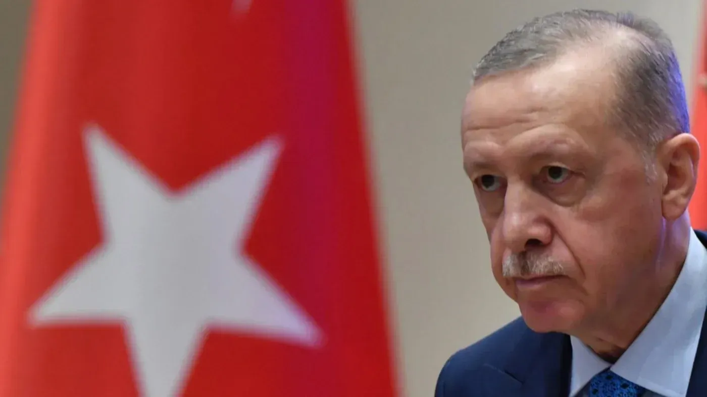 الرئيس التركي رجب طيب أردوغان أثناء إلقاء خطاب حول التصعيد العسكري الإسرائيلي في سوريا، مع العلم الوطني التركي خلفه.