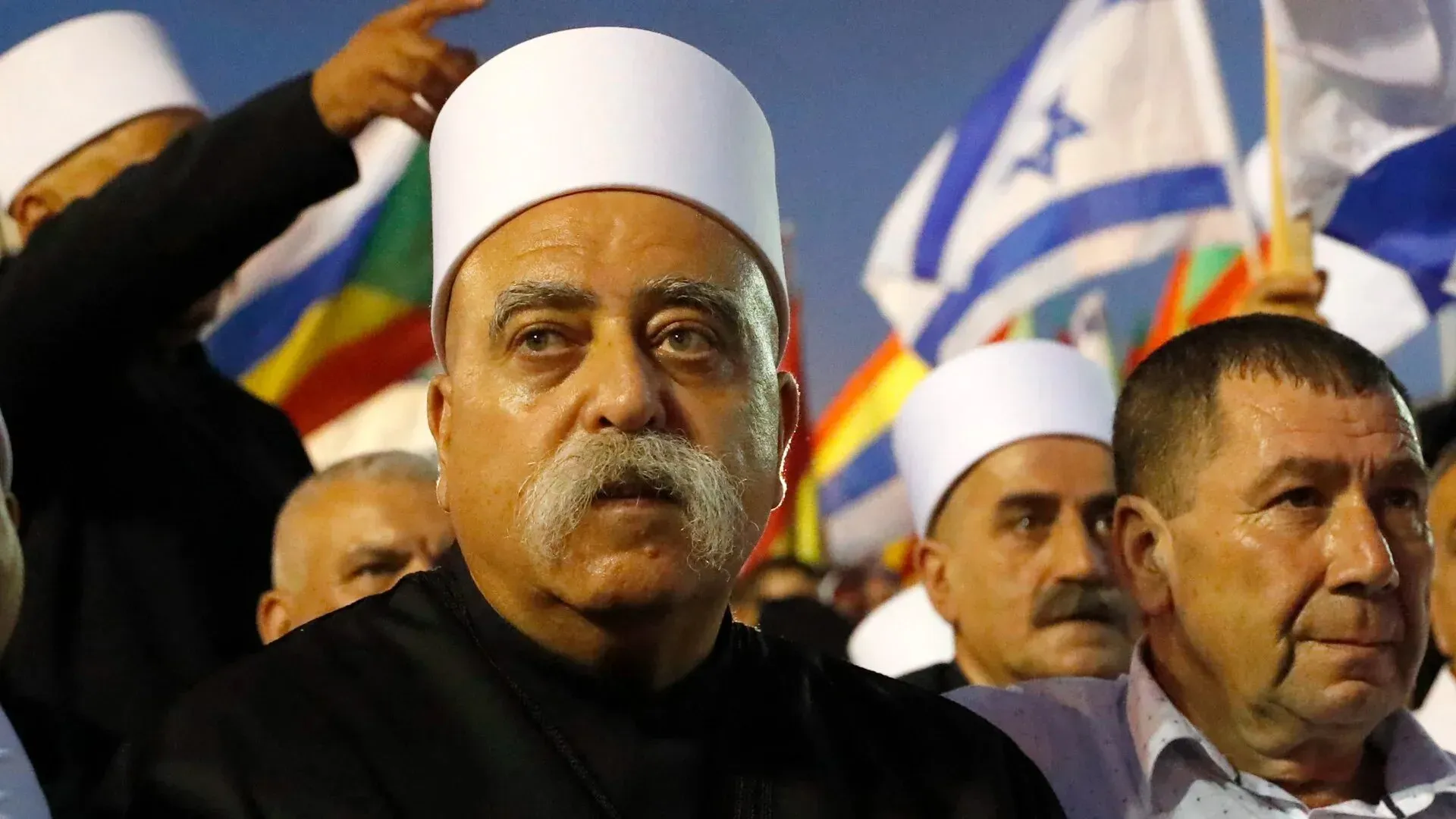 زعيم درزي إسرائيلي يتحدث أمام حشد، يحمل أعلام إسرائيل، خلال تجمع لدعم الطائفة الدرزية في سياق الوضع المتوتر في سوريا.