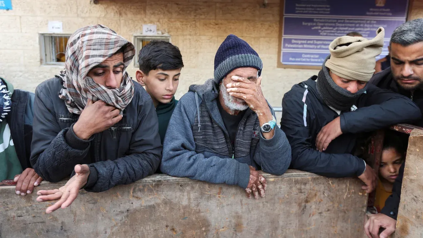 مجموعة من الأشخاص يتجمعون بقلق وحزن، يعبرون عن مشاعرهم بعد الصراع في غزة، مما يعكس التحديات الإنسانية العميقة.