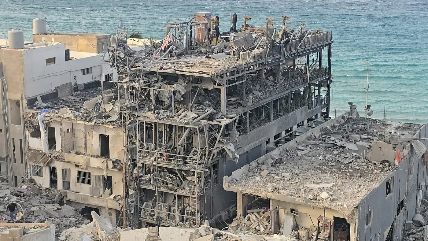 تظهر الصورة مبنى مدمر في جنوب لبنان، حيث تتناثر الأنقاض على الساحل، مما يعكس آثار الهدم الممنهج خلال النزاع.