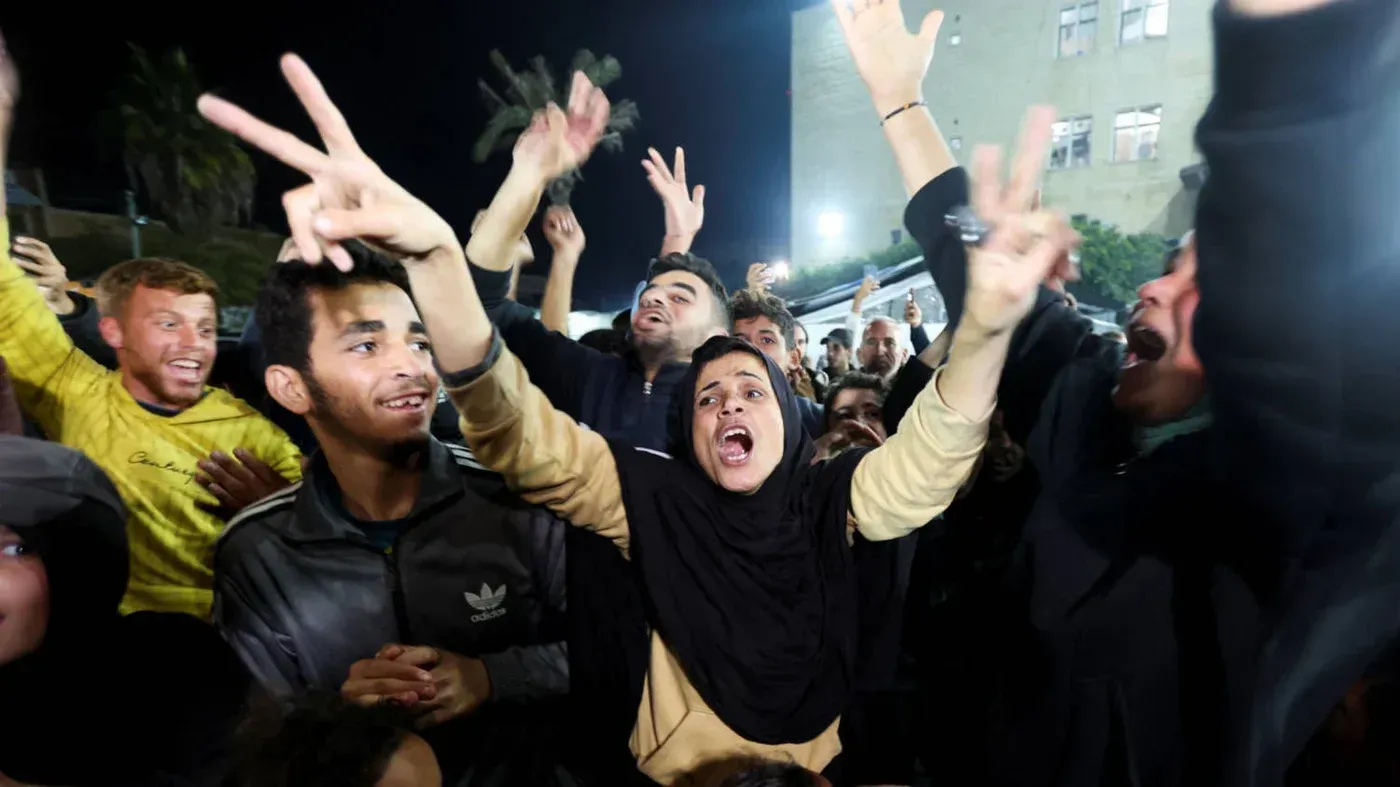 احتفال حاشد في غزة بعد إعلان وقف إطلاق النار بين إسرائيل وحماس، حيث يظهر الشباب يرفعون أيديهم بعلامة النصر ويعبرون عن فرحتهم.