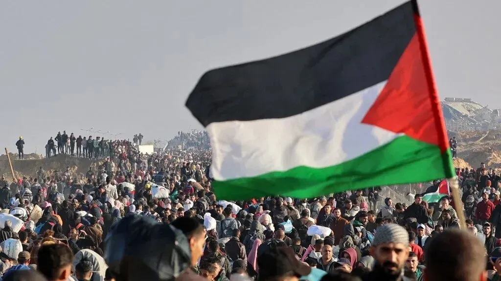 تجمع حشود كبيرة من الفلسطينيين في غزة، يرفعون العلم الفلسطيني وسط أجواء من التوتر والاحتجاجات.