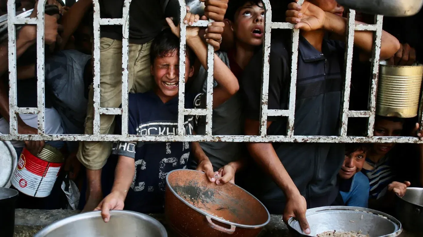 مشهد يعكس معاناة الأطفال الفلسطينيين في غزة، حيث يتزاحمون للحصول على الطعام وسط ظروف قاسية من الجوع والفقر.