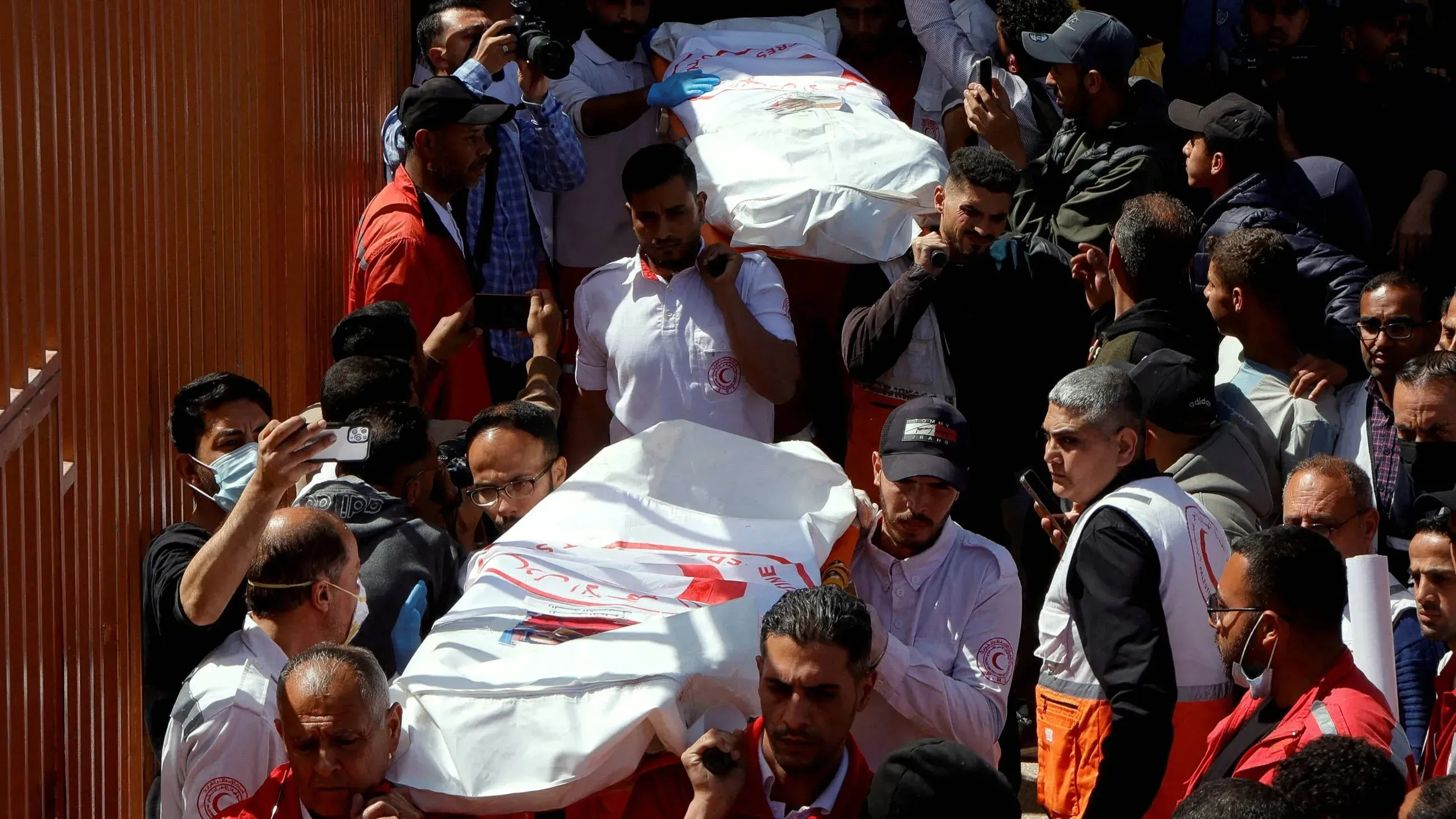 تشييع جثامين المسعفين الذين قُتلوا أثناء أداء واجبهم في غزة، وسط حشود من الناس وارتداء ملابس الهلال الأحمر.