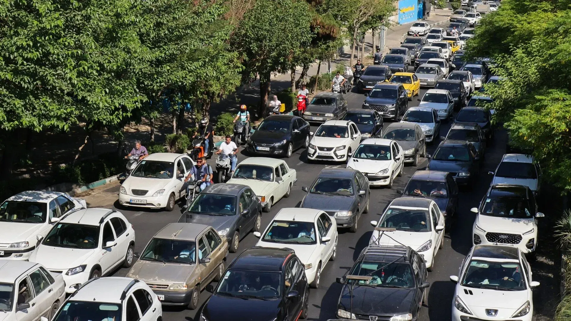 ازدحام مروري شديد في شوارع طهران، حيث تتوقف السيارات في صفوف طويلة بسبب الهجمات الإسرائيلية، مما يعكس حالة القلق بين السكان.