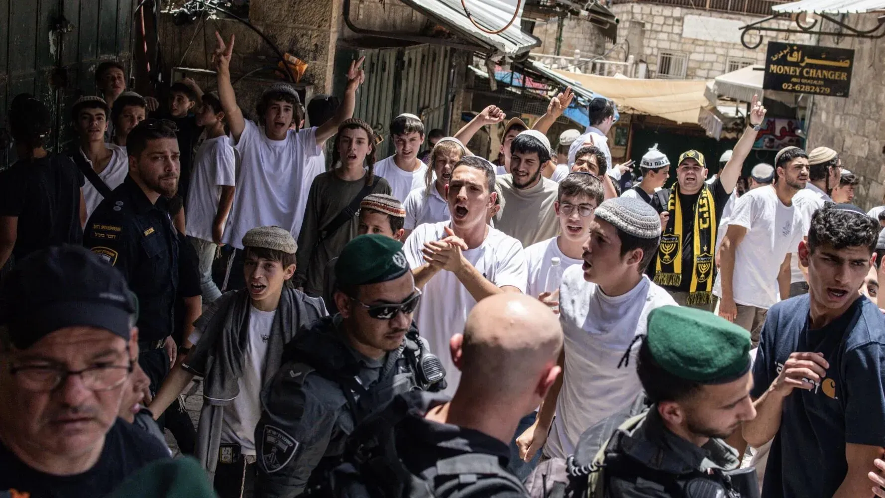مشاركون في مسيرة الأعلام بالقدس يرفعون الأعلام ويهتفون بشعارات قومية، مع وجود عناصر من الشرطة في المنطقة.