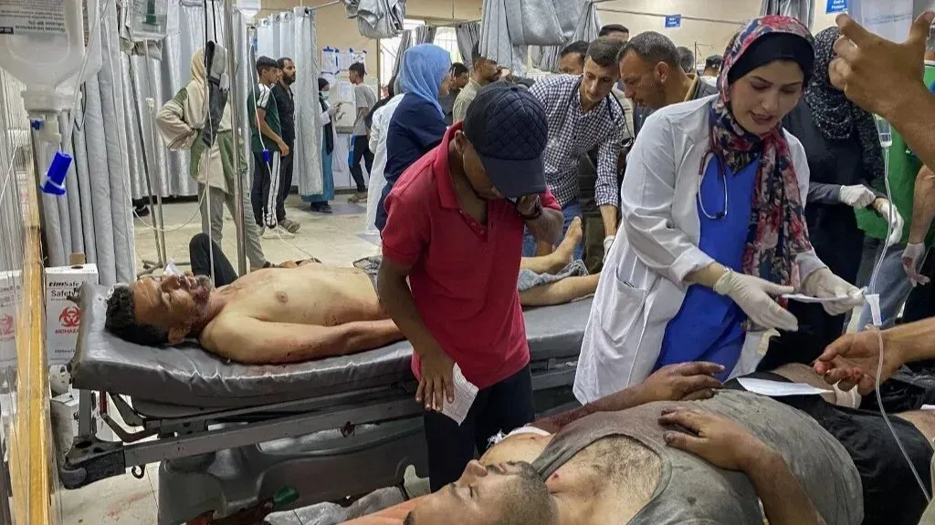 مشهد من مستشفى في غزة يظهر الأطباء والمساعدين الطبيين وهم يعالجون المصابين بعد الهجمات الإسرائيلية، مع وجود المرضى في حالة حرجة.