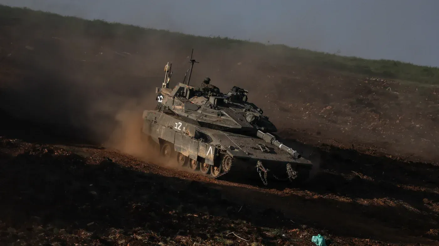 دبابة إسرائيلية تتحرك في منطقة وعرة بجنوب لبنان، وسط تصاعد التوترات العسكرية مع حزب الله، مما يعيد للأذهان أحداث عام 1982.