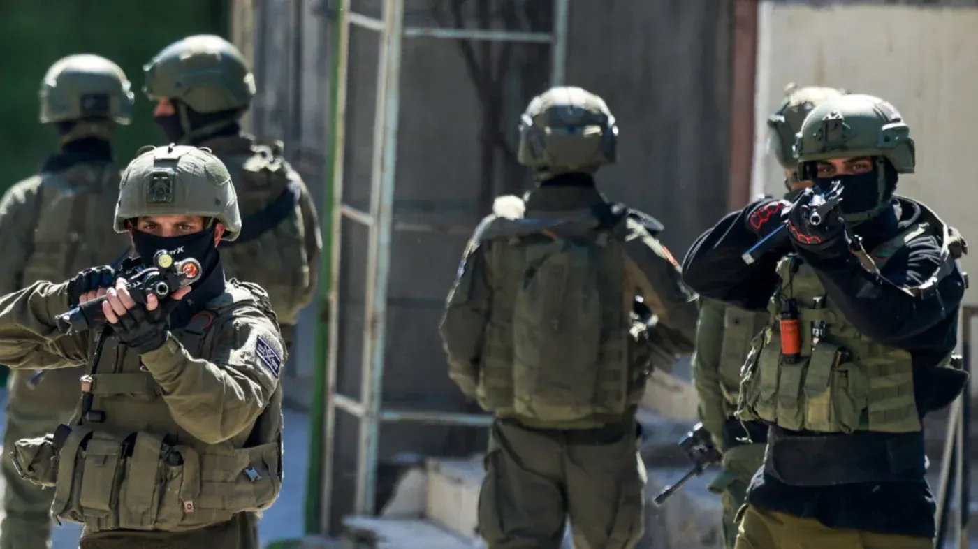 جنود إسرائيليون مدججون بالسلاح في منطقة حضرية، يعكسون تصاعد التوترات في الضفة الغربية بعد إقرار قانون الإعدام الجديد.