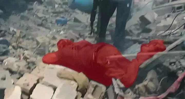 جثة ملقاة على الأرض بين الأنقاض، تظهر آثار دماء، تعكس الأثر المدمر للصراع في غزة وتسلط الضوء على تصاعد العنف.