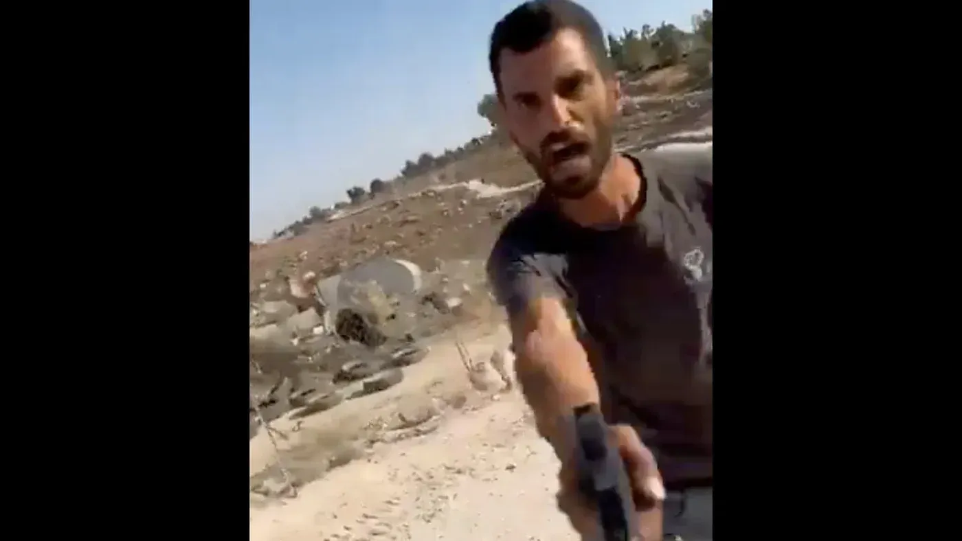 مستوطن يحمل مسدسًا ويظهر في حالة من الغضب أثناء إطلاق النار على فلسطينيين في قرية أم الخير بالضفة الغربية، حيث قُتل الناشط عودة الهذالين.