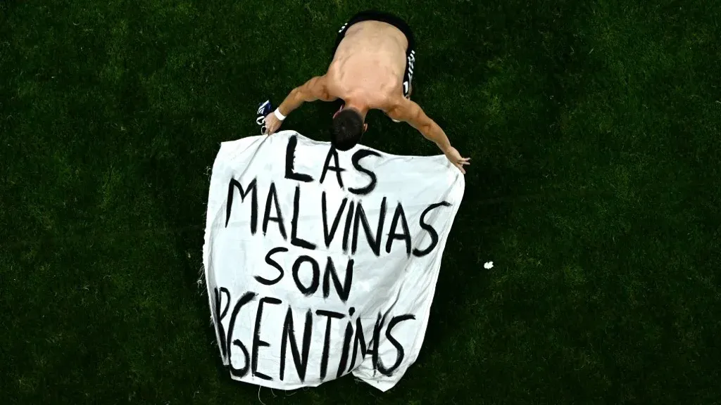 لاعب أرجنتيني يحمل لافتة مكتوب عليها "مالفيناس أرجنتينية" تعبيراً عن المطالب السيادية خلال كأس العالم بعد فوز الأرجنتين على إنجلترا.