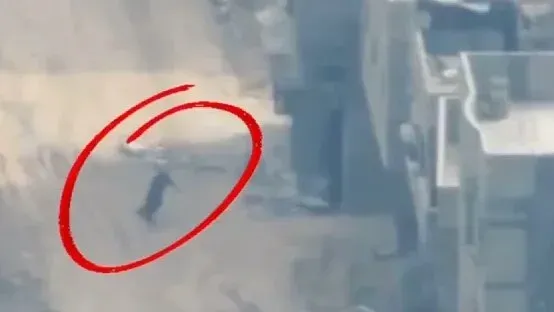 طائرة بدون طيار من نظام سبايك فايرفلاي تتعقب شخصًا في غزة، مع وجود حطام في الخلفية، ضمن فيديو ترويجي لشركة رافائيل.