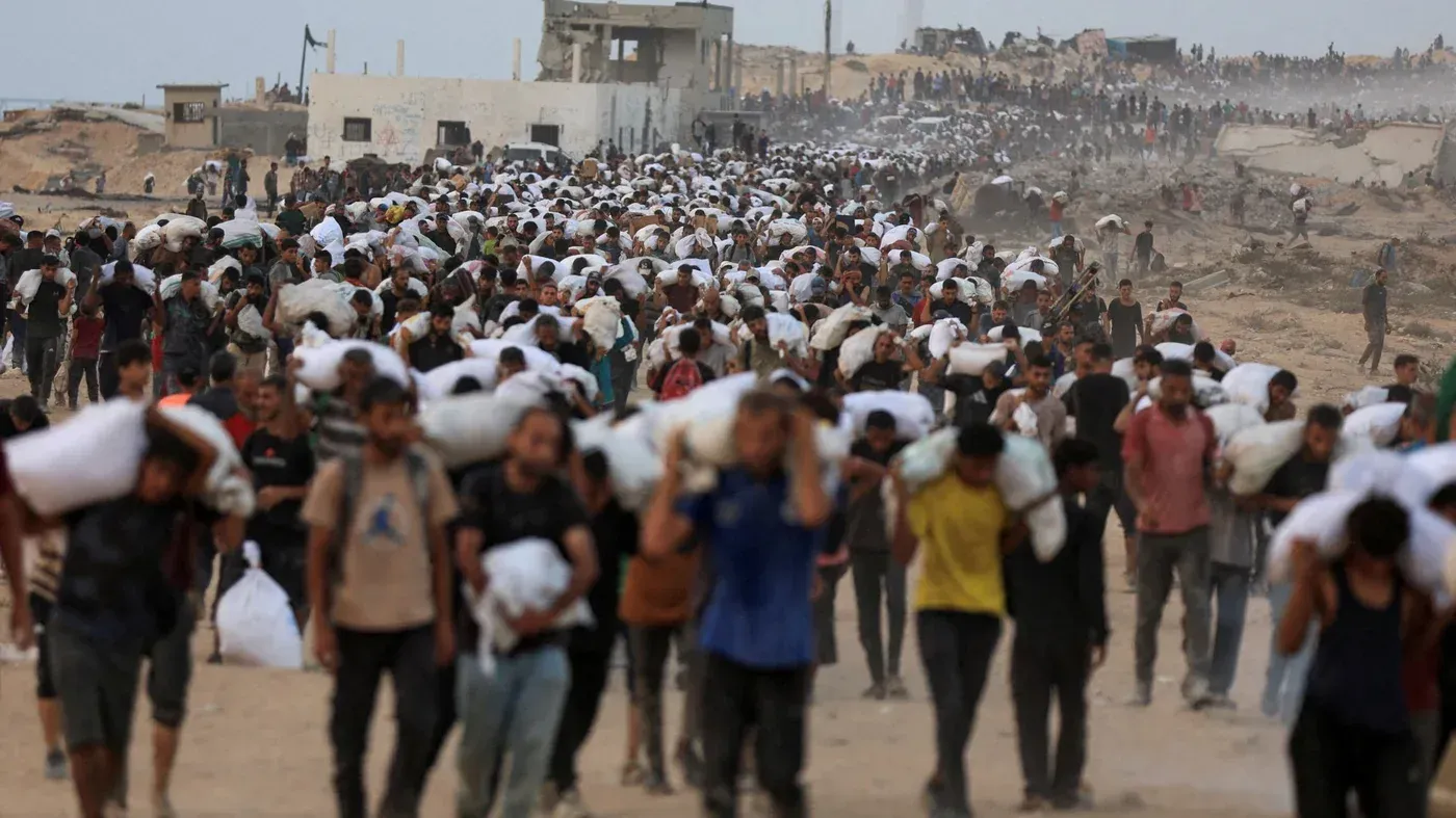 آلاف من الفلسطينيين يحملون الأمتعة أثناء النزوح في غزة، وسط الدمار الناتج عن الحملة العسكرية المستمرة.