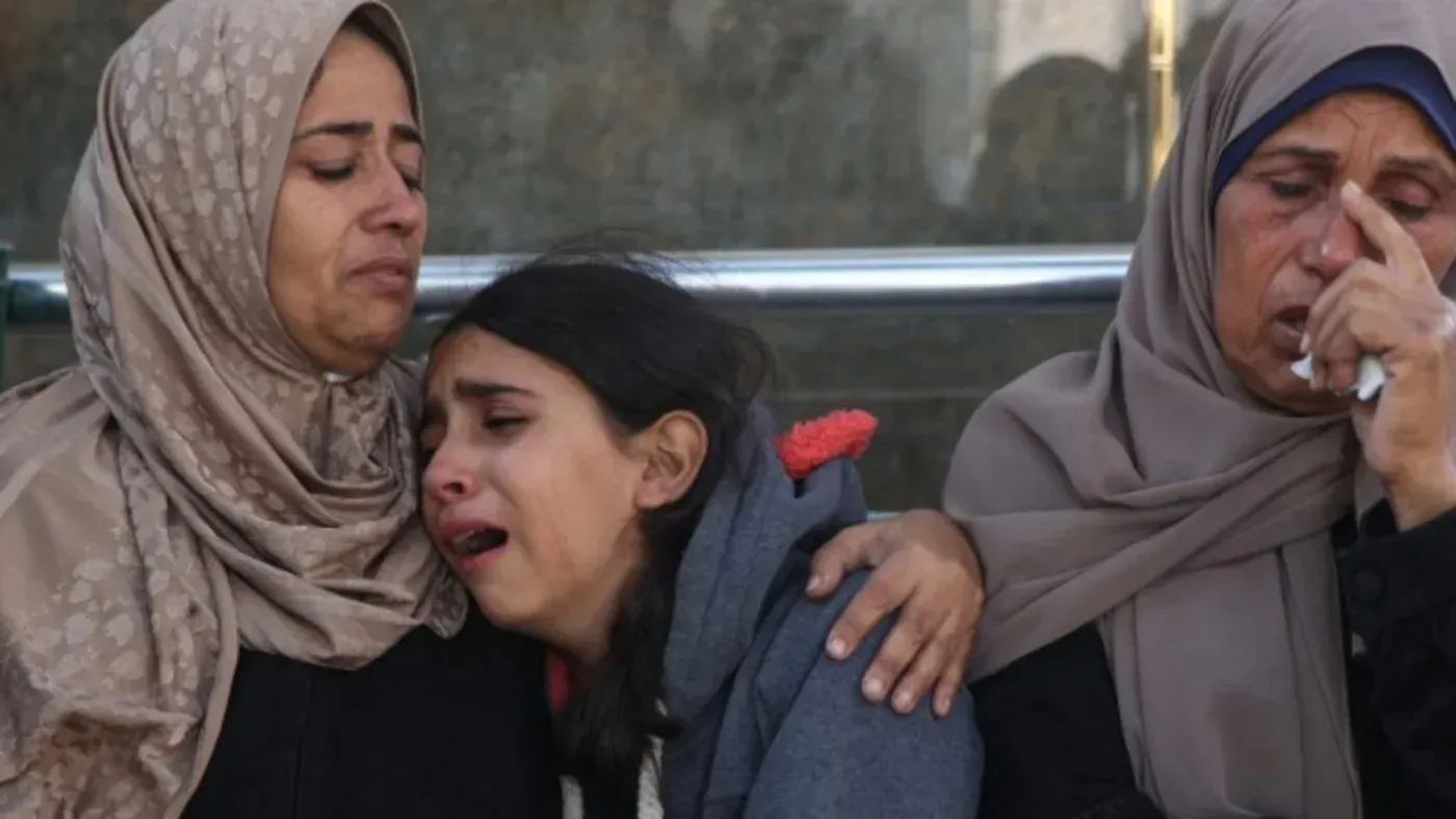 نساء وأطفال يبكون في مشهد مؤثر يعكس معاناة الفلسطينيين في غزة، في ظل الأزمات الإنسانية المستمرة.