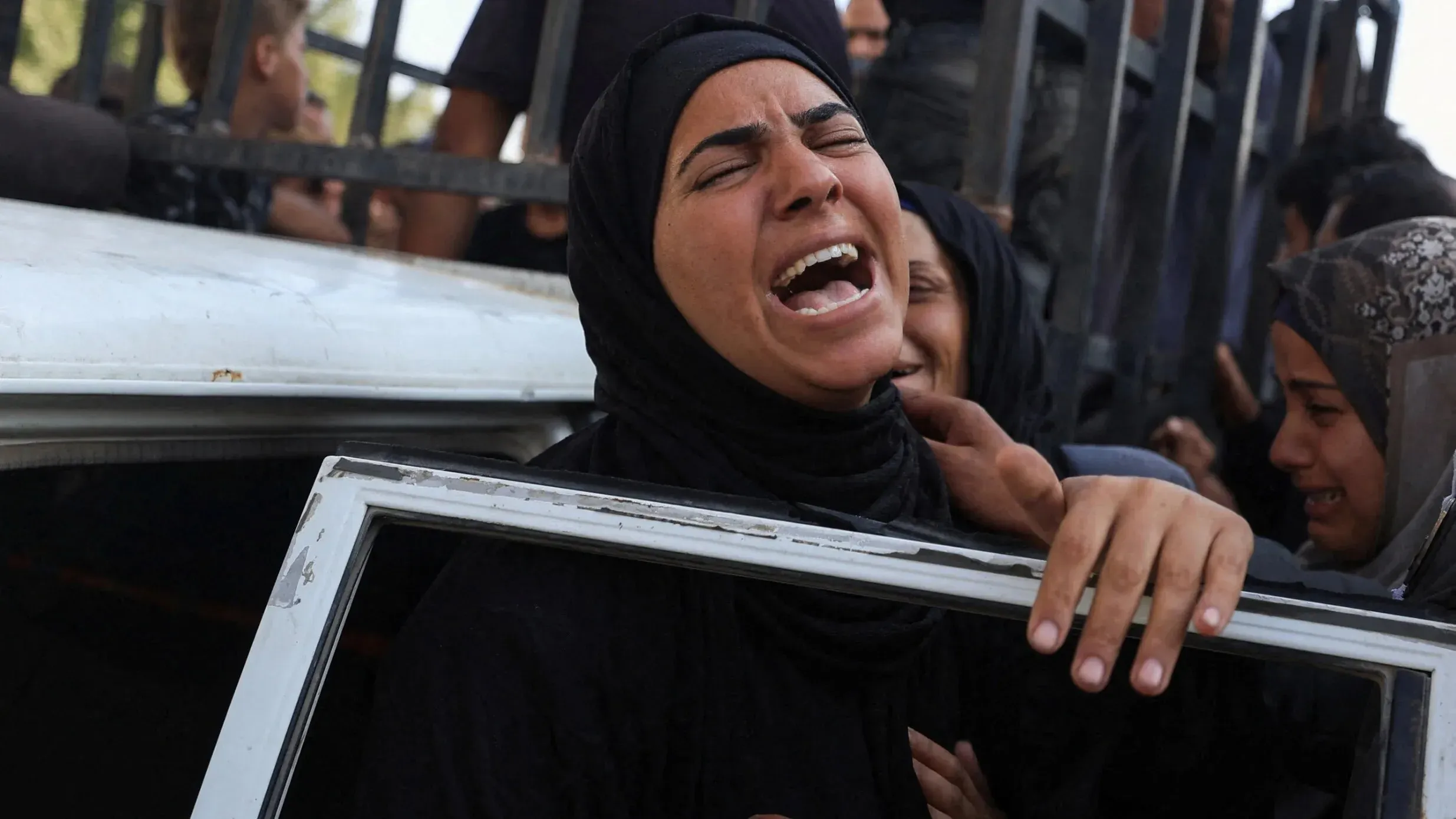امرأة ترتدي الحجاب تعبر عن حزن عميق أثناء انتظار المساعدات الإنسانية، في ظل تصاعد العنف في قطاع غزة.