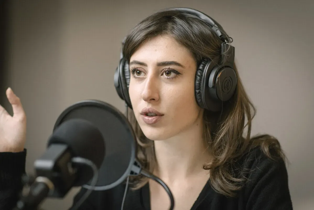 سيسيليا سالا، الصحفية الإيطالية، تتحدث في استوديو مع سماعات رأس، تعبيرها يدل على التركيز أثناء النقاش حول قضاياها الأخيرة في إيران.