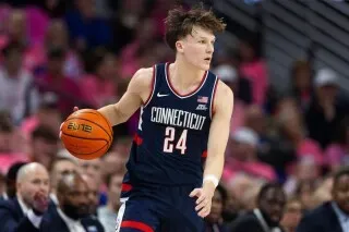 برايلون مولينز، لاعب فريق يوكون، يحمل كرة السلة خلال مباراة، مرتديًا زي الفريق، مع التركيز على الأداء في مواجهة بتلر.