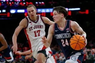 برايلون مولينز، لاعب فريق يوكون، يتقدم بالكرة خلال مباراة ضد فريق سانت جون، مع لاعب منافس يلاحقه.