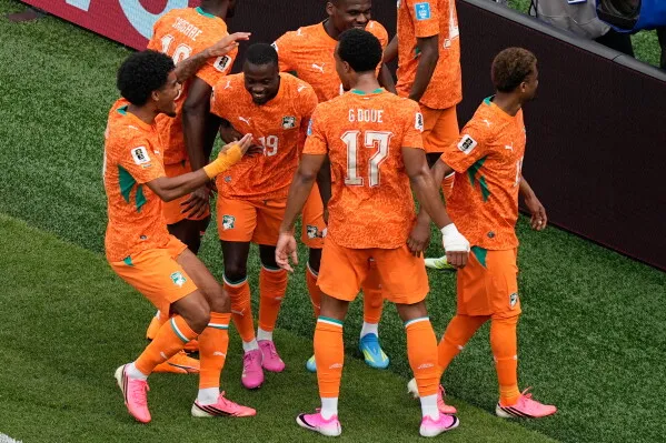 احتفال لاعبي منتخب ساحل العاج بعد تسجيل الأهداف في مباراة كأس العالم ضد كوراساو، حيث يظهر الحماس والتفاعل بين اللاعبين.