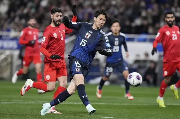 لاعب ياباني يرتدي الرقم 15 يتجه نحو الكرة خلال مباراة ضد البحرين، حيث حقق منتخب اليابان فوزاً 2-0 وتأهل لكأس العالم 2026.