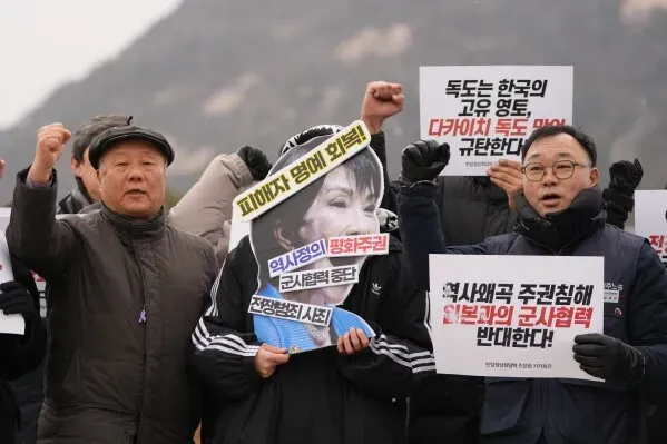 محتجون يحملون لافتات تعبر عن مطالبهم بشأن التاريخ والعلاقات اليابانية الكورية، في سياق قمة بين رئيسة وزراء اليابان ورئيس كوريا الجنوبية.