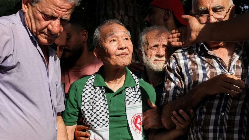 كوزو أوكاموتو الياباني محاط بفلسطينيين في تجمع تضامني ببيروت، رمز النضال والدعم للقضية الفلسطينية.