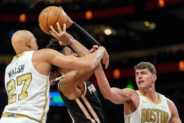 لقطة من مباراة كرة السلة بين بوسطن سيلتيكس وأتلانتا هوكس، حيث يتنافس اللاعبون على الكرة وسط أجواء حماسية في الملعب.