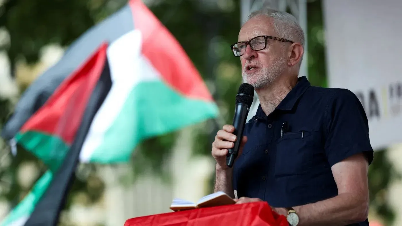 جيريمي كوربين يتحدث في فعالية دعم لفلسطين، مع العلم الفلسطيني خلفه، معبرًا عن دعوته لتحقيق العدالة وفضح التواطؤ البريطاني.
