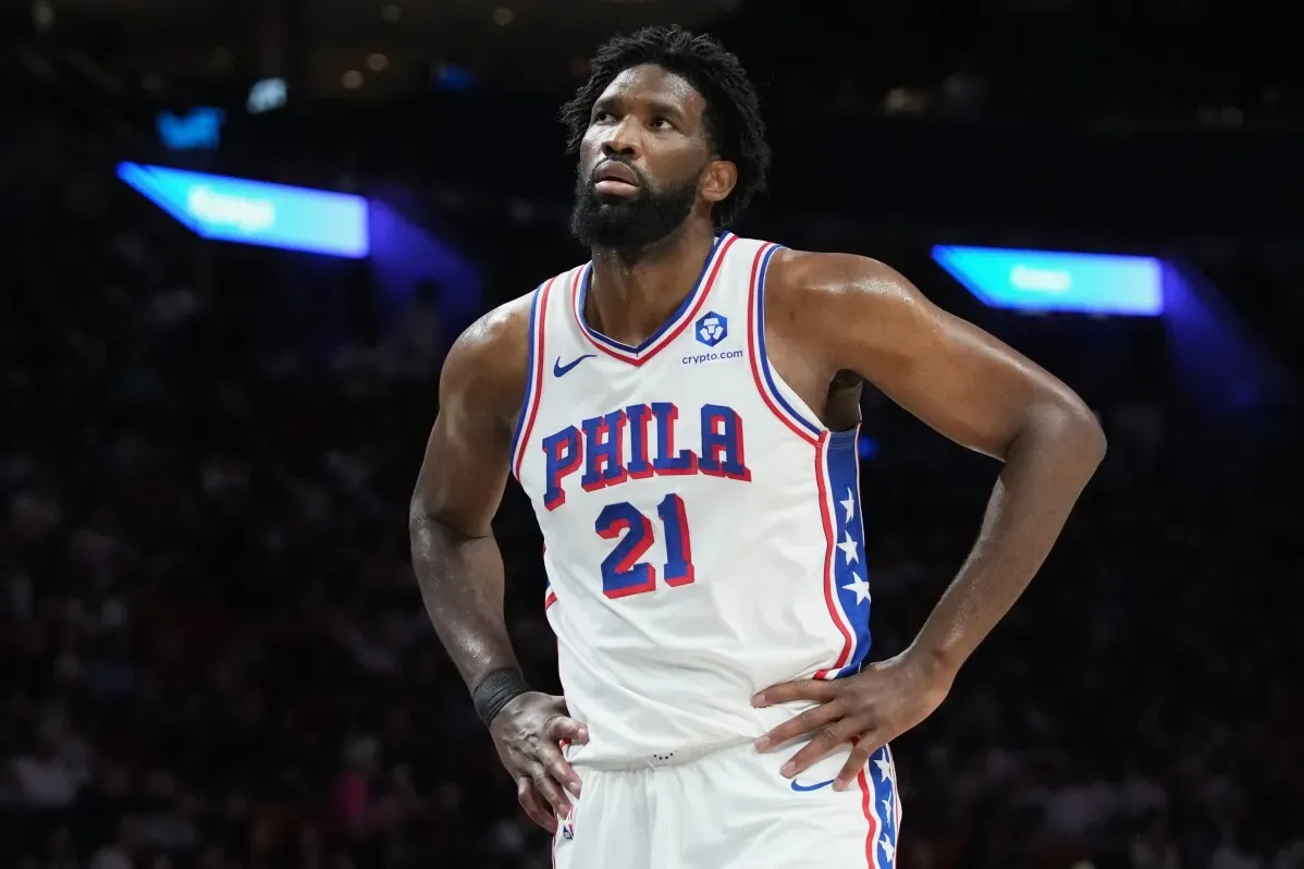 جويل إمبيد، لاعب فريق فيلادلفيا 76ers، يظهر بملامح الغضب أثناء مباراة، مع التركيز على عدم مشاركته بسبب الإصابة والمرض.