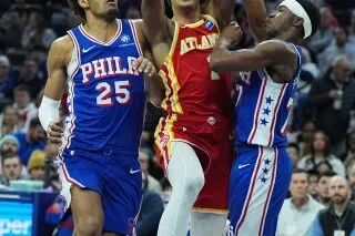 جالين جونسون من أتلانتا هوكس يسجل نقطة خلال مباراة ضد فيلادلفيا 76ers، حيث يظهر المنافسة الشديدة بين اللاعبين.