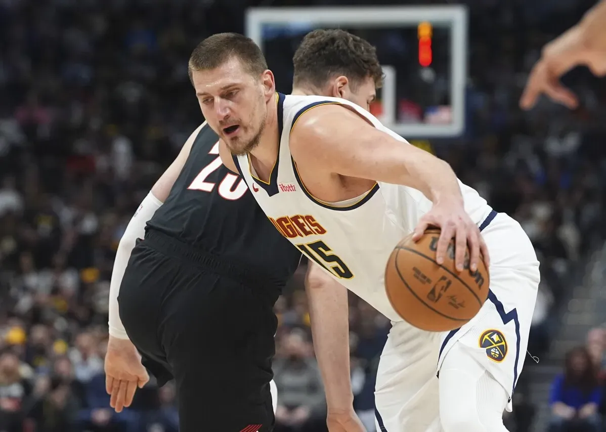 نيكولا جوكيتش يتنافس مع لاعب من بورتلاند، حاملاً الكرة، خلال مباراة دنفر ناجتس ضد بورتلاند تريل بليزرز في الدوري الأمريكي للمحترفين.