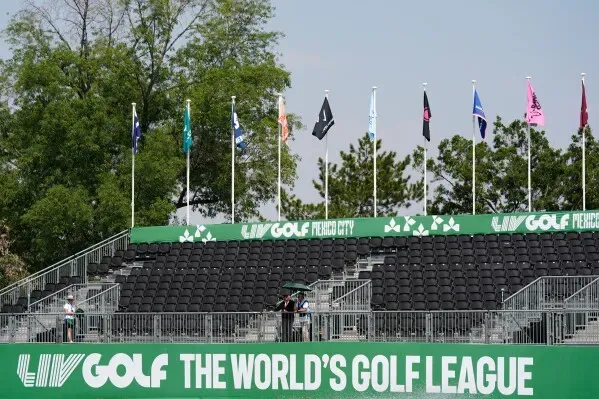 مدرجات فارغة في بطولة LIV Golf بالمكسيك، مع أعلام الفرق تتمايل في الهواء، تعكس أجواء المنافسة والتوتر في عالم الجولف.