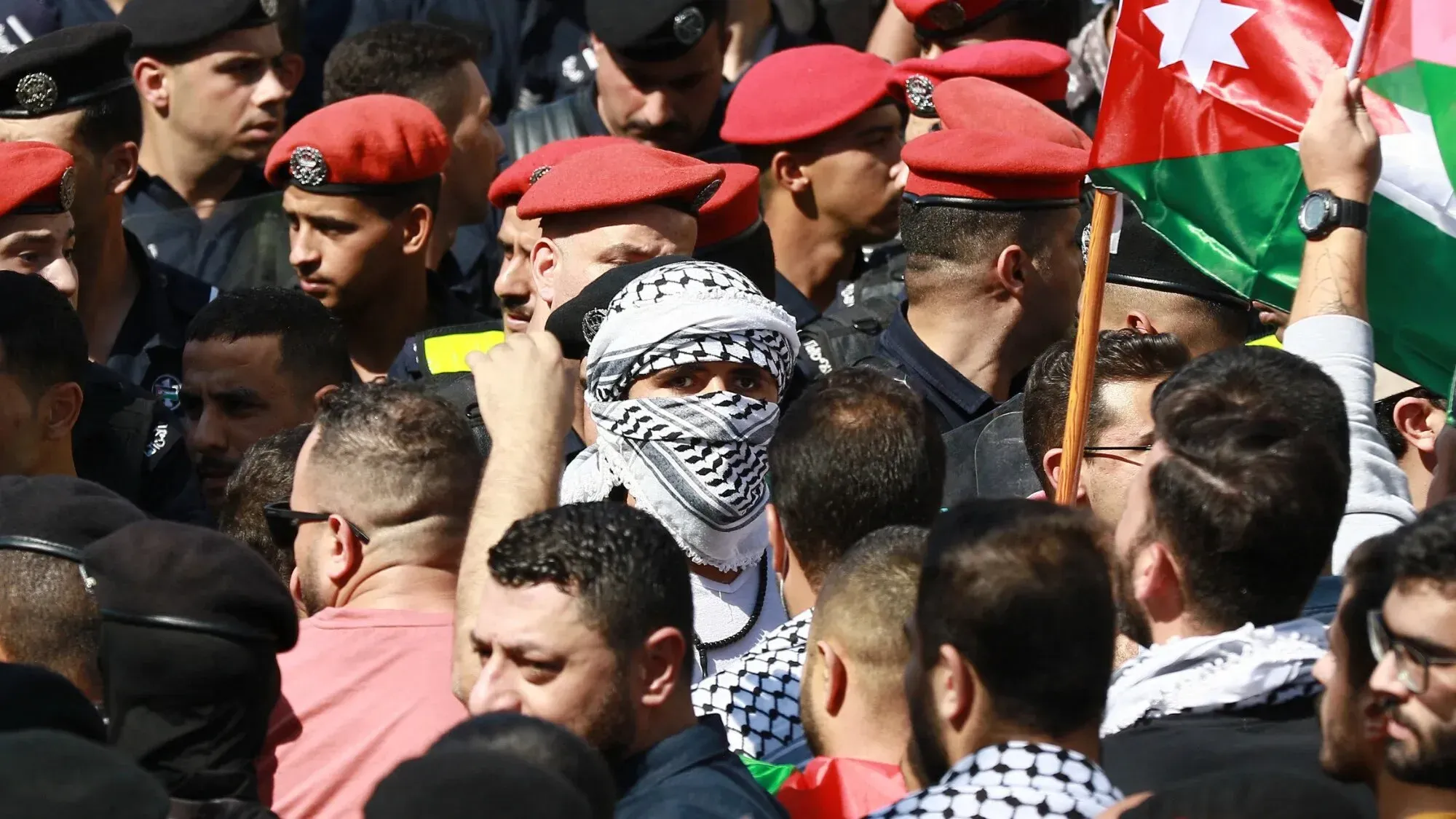 تجمع حشود من المتظاهرين في الأردن، مع وجود عناصر من الأمن، تعبيرًا عن دعمهم لفلسطين في سياق قضية سياسية تتعلق بجماعة الإخوان المسلمين.