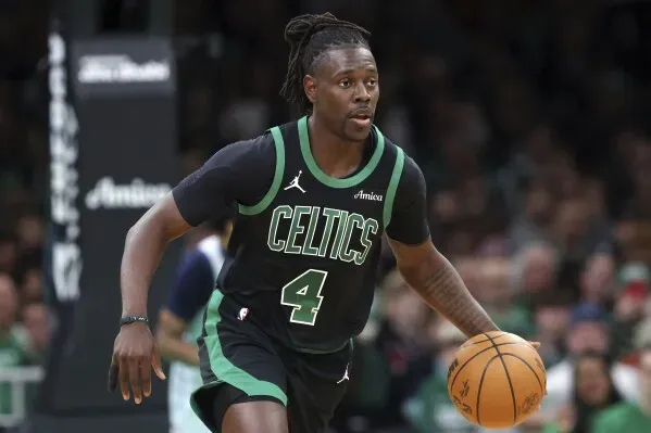 جونيور هوليداي، لاعب بوسطن سيلتيكس، يت dribble الكرة خلال مباراة، مع التركيز على أدائه في الدوري الأمريكي للمحترفين.