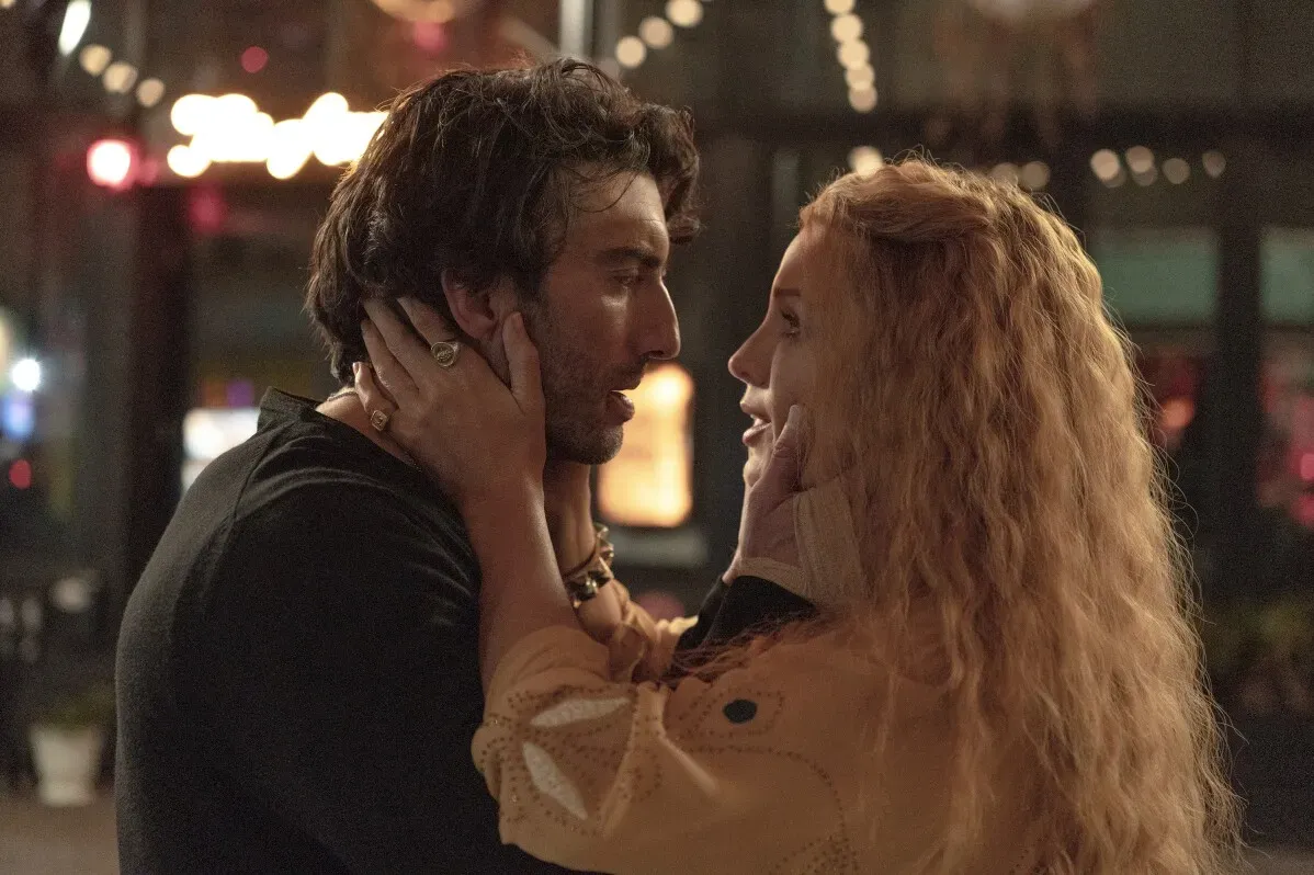مشهد رومانسي من فيلم \"It Ends With Us\"، يظهر فيه ممثل وممثلة يتبادلان نظرات عاطفية في أجواء مفعمة بالحب.