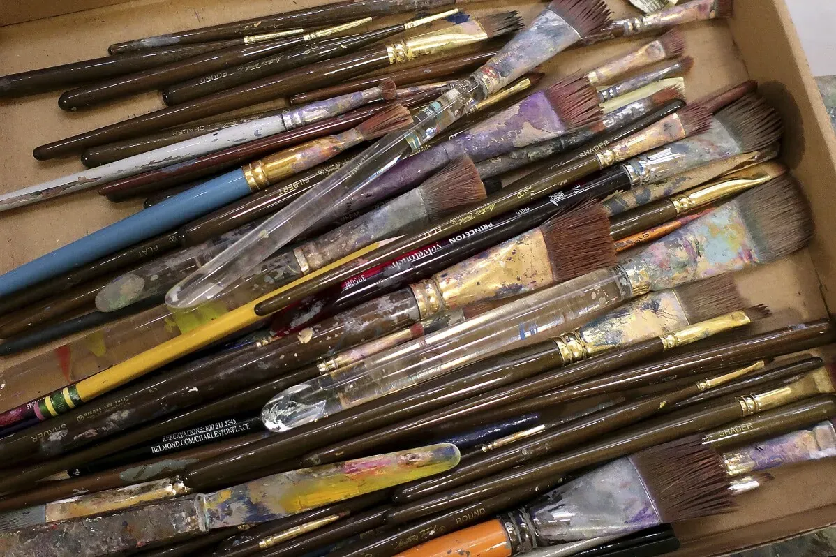 فرش رسم ملونة متنوعة مرصوصة بشكل عشوائي في صندوق، تعكس العمل الفني الذي أُنتج لتكريم نضال النساء من أجل حقوق التصويت في كانساس.
