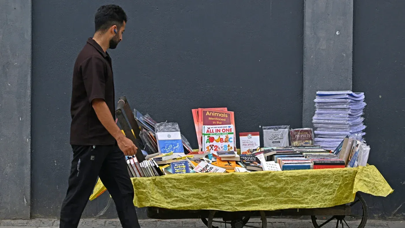 رجل يسير بجانب عربة كتب في كشمير، حيث تُظهر العربة مجموعة متنوعة من الكتب، في سياق حظر الحكومة الهندية للكتب المثيرة للجدل.