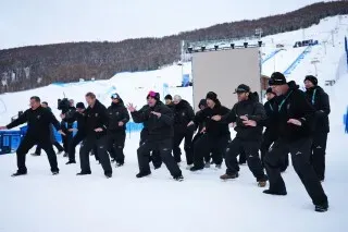 مجموعة من الرياضيين الكيويين يؤدون رقصة الهاكا التقليدية على الثلج، احتفالاً بمشاركة نيوزيلندا في الألعاب الأولمبية الشتوية.