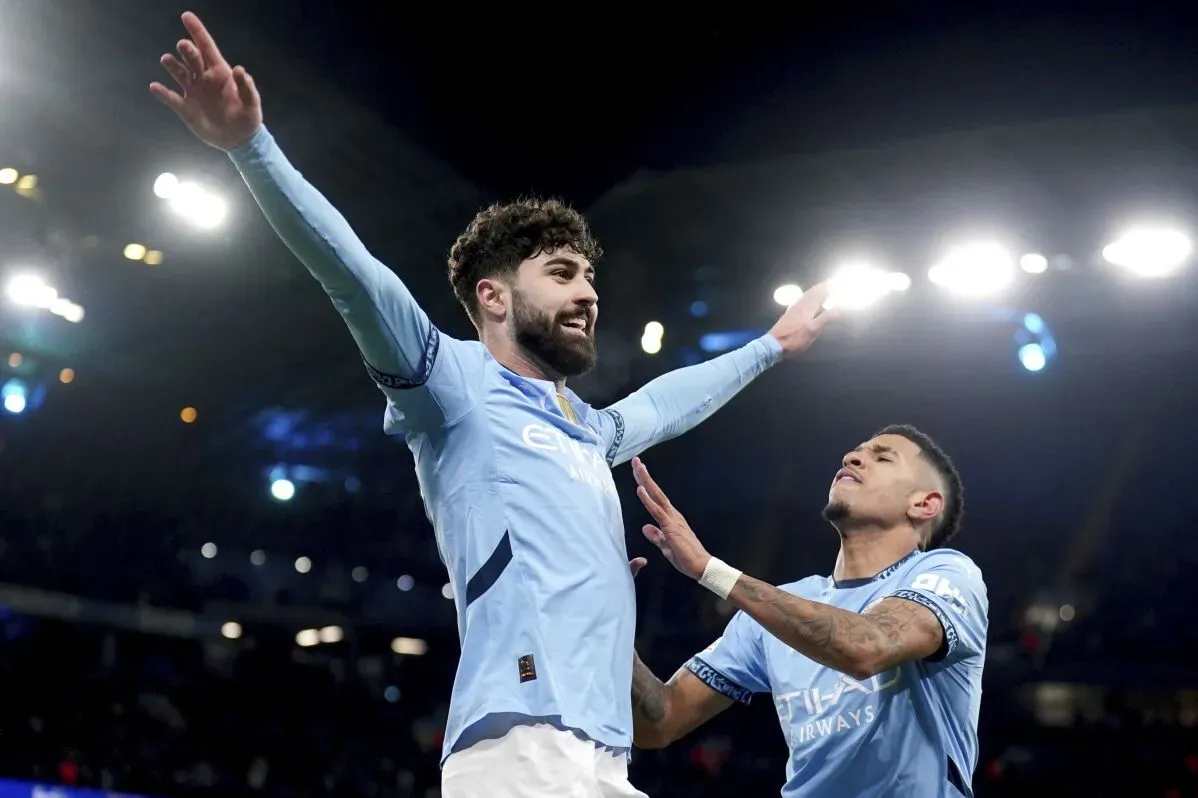 فرحة لاعبي مانشستر سيتي بعد تسجيل هدف مهم في مباراة دوري أبطال أوروبا، مع أضواء الملعب في الخلفية.