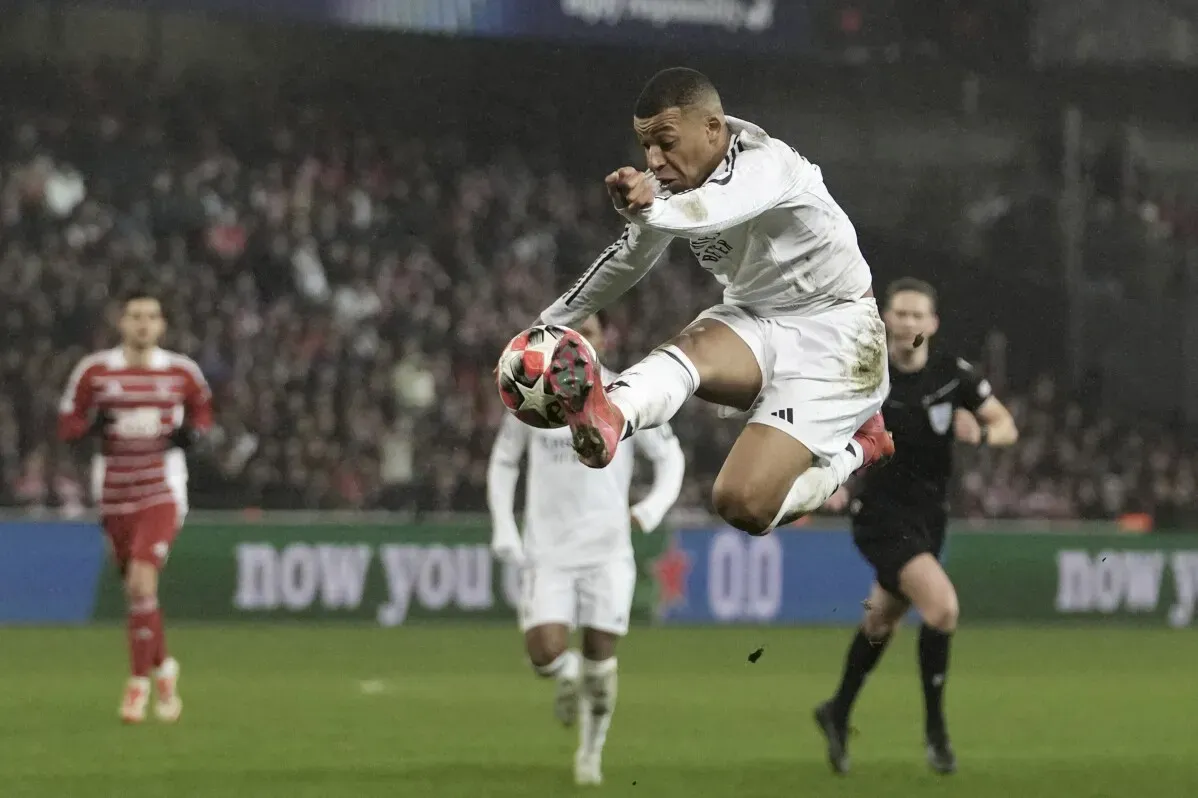 لاعب كرة القدم يقفز في الهواء أثناء مباراة، مع وجود مشجعين في الخلفية. تنعكس الإثارة لأحداث دوري أبطال أوروبا.