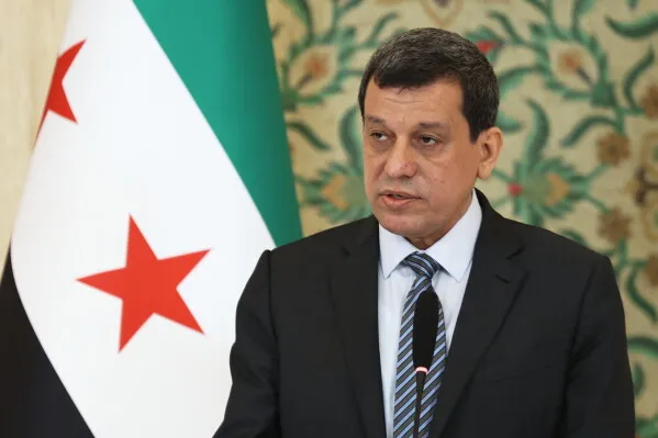 أحمد الشرع، الرئيس الانتقالي السوري، يتحدث في مؤتمر صحفي أمام علم الثورة السورية، مع إعلان حل قوات سوريا الديمقراطية وتعزيز حقوق الأكراد.