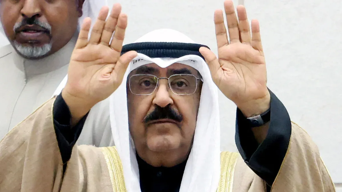 رجل كويتي يرتدي الزي التقليدي يرفع يديه خلال اجتماع رسمي يعكس المفاوضات الأمنية بين الكويت وباكستان لتوسيع التعاون الدفاعي.