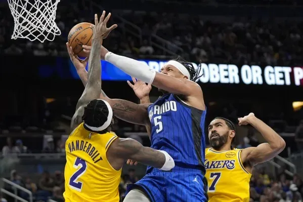 لاعب أورلاندو ماجيك، فرانز واجنر، يسجل نقطة تحت ضغط من لاعبي لوس أنجلوس ليكرز، في مباراة مثيرة بالدوري الأمريكي للمحترفين.