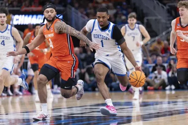 لامونت بتلر، لاعب كرة سلة من كنتاكي، يركض بالكرة متجاوزًا مدافع إلينوي في مباراة NCAA، مع التركيز على المنافسة والفوز بالبطولة.