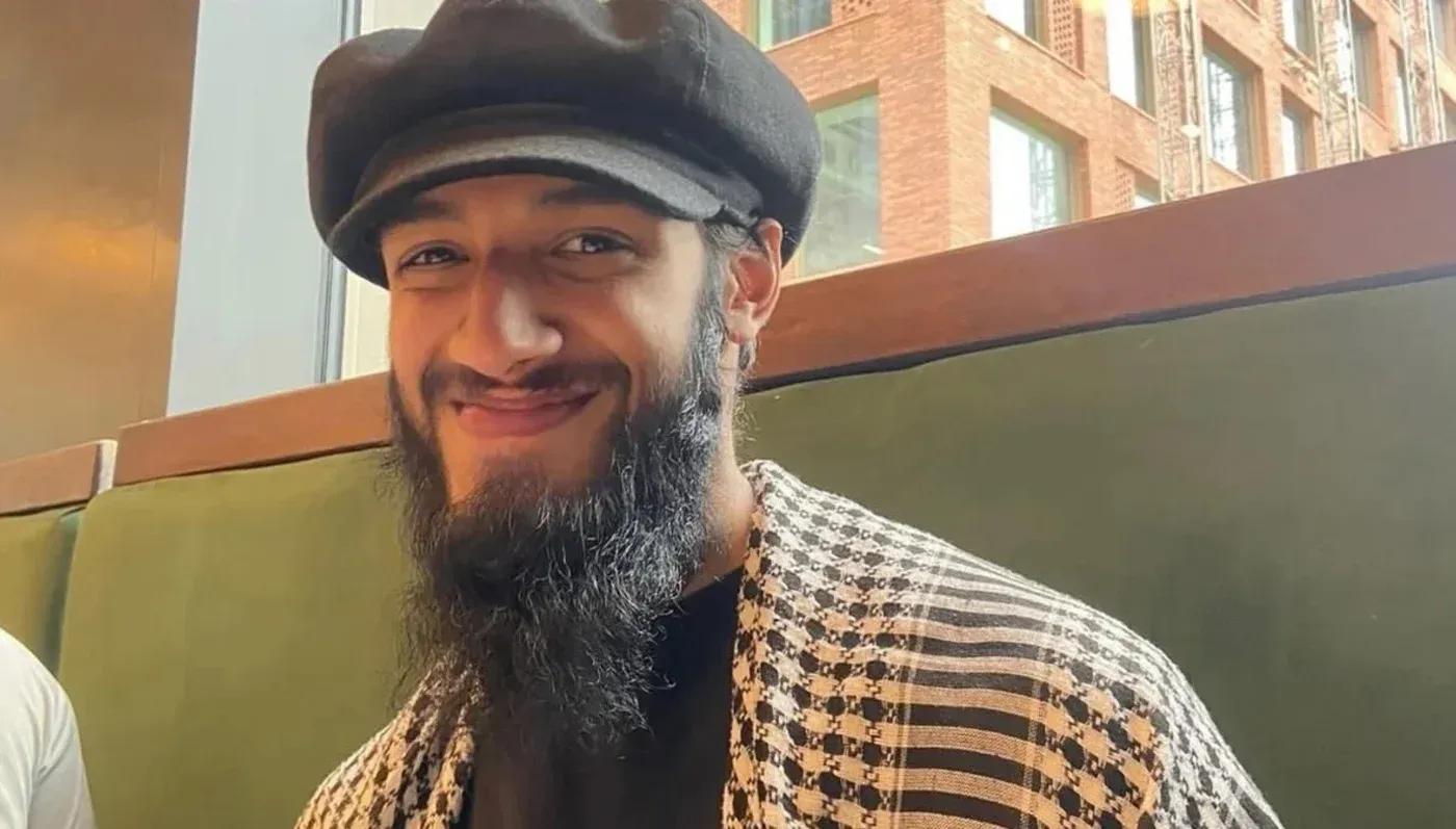 محمد عمر خالد، سجين مضرب عن الطعام، مبتسم في صورة، يرتدي قبعة وقميصًا مزخرفًا، يعبر عن قلقه بشأن ظروف اعتقاله.