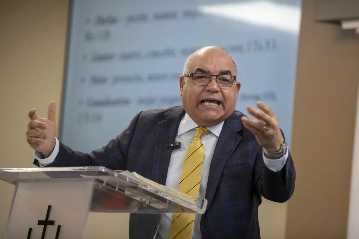 أسقف يتحدث بحماس خلال قداس، مع خلفية تتضمن نصوص دينية، معبراً عن قلقه بشأن تأثير سياسات الهجرة على الكنائس.